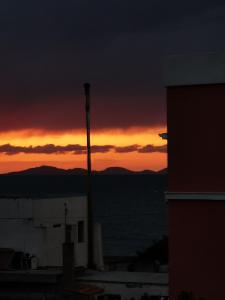 un coucher de soleil est visible depuis un bâtiment avec un poteau dans l'établissement Casa Mea, à Porto Torres