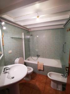 La salle de bains est pourvue d'un lavabo, de toilettes et d'une baignoire. dans l'établissement Casa Mea, à Porto Torres