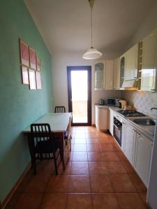 - une cuisine avec une table, une table et des chaises dans l'établissement Casa Mea, à Porto Torres