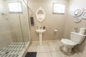 a bathroom with a shower and a toilet and a sink at Faraway Lodge in Durban