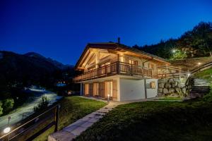 uma casa numa colina à noite com luzes em Chalet Joli em La Tzoumaz