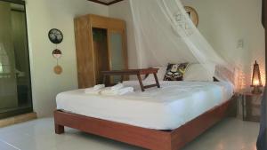 ein Schlafzimmer mit einem Bett mit Handtüchern darauf in der Unterkunft Cassiopeia Srithanu Apartments in Srithanu