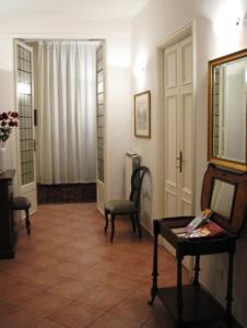 un pasillo con 2 sillas y una mesa en una habitación en B&B Fiordaliso, en Florencia