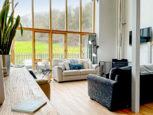 a living room with a couch and a large window at Moss Cottage in Fownhope