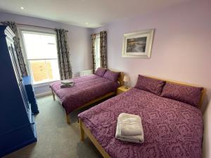 een slaapkamer met 2 bedden en een raam bij Clarendon Luxury Apartment in Woodhall Spa