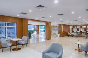 a lobby with chairs and tables in a building at Soaltee Westend Itahari in Itahari