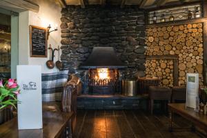 a fireplace in a room with a stone wall at The Wild Boar in Bowness-on-Windermere