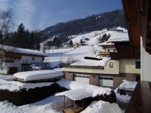 a snow covered city with buildings and a mountain at Ferienwohnung Birkenheim in Fügenberg