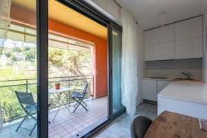 eine Küche mit einem Balkon mit einem Tisch und Stühlen in der Unterkunft JOIVY Cosy flat with splendid sea view in Zoagli
