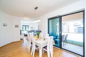 - une salle à manger et un salon avec une table et des chaises blanches dans l'établissement Apartment Dubrovnik Clouds, à Dubrovnik