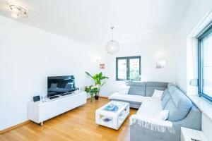 - un salon avec un canapé et une télévision dans l'établissement Apartment Dubrovnik Clouds, à Dubrovnik