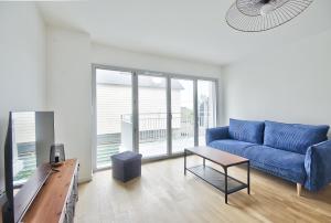 uma sala de estar com um sofá azul e uma mesa em Ecapade en duo a Pleneuf-Val-Andre em Pléneuf-Val-André