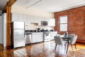 a kitchen with a refrigerator and a table with chairs at S End Loft w Pool Art Gallery Steps to T BOS-356 in Boston