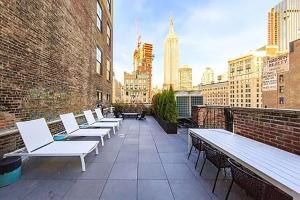 a row of white chairs and tables on a building at NoMad 1br w wd elevator roof NYC-1055 in New York