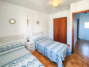 una camera con 2 letti e un pavimento in legno di Adosados Boix Serrat a Peñíscola