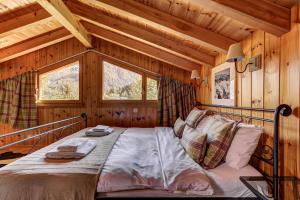 a bedroom with a bed in a wooden cabin at Chalet Khione in La Tzoumaz