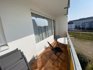 d'un balcon avec une table, des chaises et une fenêtre. dans l'établissement Achtern Diek, Whg 9, à Grömitz
