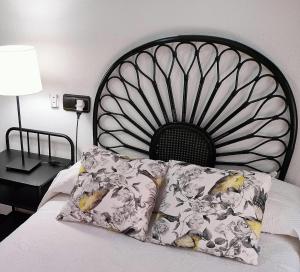- un lit avec une tête de lit noire et des oreillers dans l'établissement Vivienda con Parking incluido - Zona Van Dyck, à Salamanque