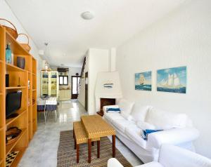 een woonkamer met een witte bank en een tv bij Avra Chanioti in Hanioti