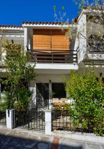 una casa con balcón y una mesa frente a ella en Avra Chanioti, en Chaniotis
