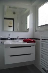 a white bathroom with a sink and a mirror at Ferienhaus in Waldkatzenbach modern & renoviert in Waldbrunn +8 photos