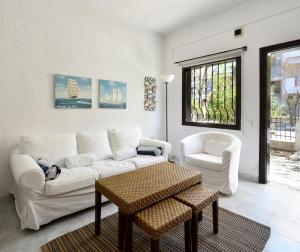 a living room with a white couch and a chair at Avra Chanioti in Hanioti