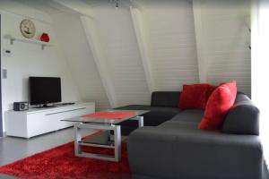 uma sala de estar com um sofá e uma mesa em Ferienhaus in Waldkatzenbach modern & renoviert em Waldbrunn