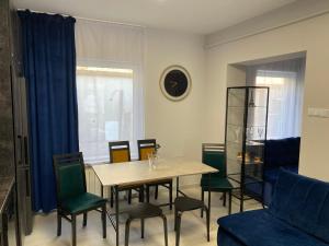 a dining room with a table and chairs and a couch at Diament Apartment in Krynica Zdrój