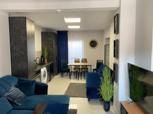 a living room with a blue couch and a table at Diament Apartment in Krynica Zdrój