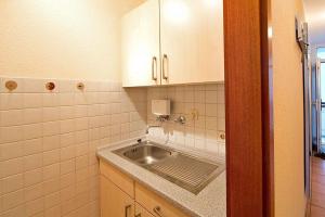 baño pequeño con lavabo y armarios blancos en Ferienwohnung-111-im-Berliner-Hof, en Scharbeutz