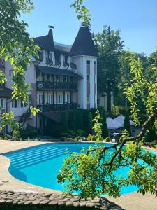a large house with a swimming pool in front of it at Готель Мараморош in Shaian