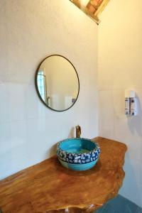 uma casa de banho com uma tigela numa mesa com um espelho em Lim Village - Nam Ban em Namban