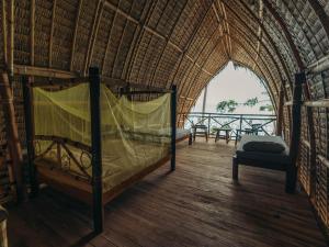 una camera con un letto in una capanna di paglia di Isla - The Island Experience a El Nido