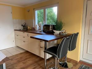 ヴィークにあるFerienhaus Brise - Schmugglerhusのキッチン(テーブル、椅子2脚、電子レンジ付) +6枚の写真
