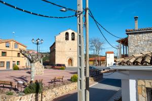 a street with a church and a clock tower at Cuencaloft Casa Rural Zarzuela in Zarzuela