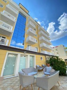 a building with chairs and a table in front of it at Residence T2 in Rimini