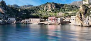 a group of buildings on the shore of a body of water at A lu Puzziddu in Castellammare del Golfo