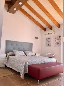 um quarto com uma cama grande e um repousa-pés vermelhos em Binimont em Sant Lluis