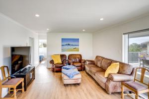 ein Wohnzimmer mit Ledermöbeln und einem TV in der Unterkunft Coastal Haven - Waimarama Holiday Home in Waimarama