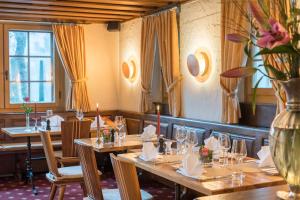 a restaurant with wooden tables and chairs and a vase with flowers at Schweizerhaus Swiss Quality Hotel in Maloja +36 photos