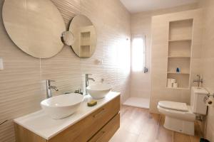 een badkamer met 2 wastafels, een toilet en een spiegel bij Cuencaloft Zarzuela in Zarzuela