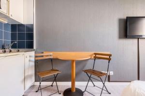 Una cocina con una mesa de madera y dos taburetes. en Marseille Prado Perier, en Marsella