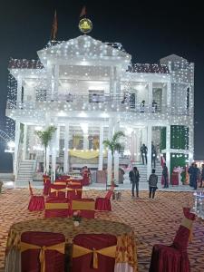 un gran edificio blanco con luces encendidas por la noche en RD Palace and Resort, en Lucknow
