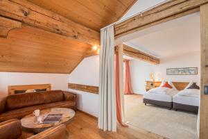 ein Wohnzimmer mit einem Sofa und einem Bett in der Unterkunft Schweizerhaus Swiss Quality Hotel in Maloja