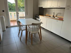 a kitchen with a table and chairs and a sink at Appartamenti al Cigno in Lignano Sabbiadoro +11 photos