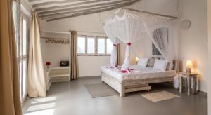 una camera con un letto bianco a baldacchino di Casamia Suites a Diani Beach