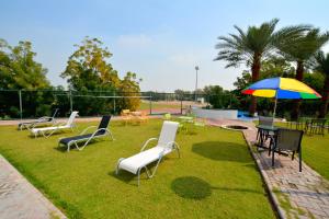 a group of chairs and tables with an umbrella at Dubai Youth Hotel in Dubai