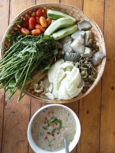 talerz jedzenia z warzywami i miskę zupy w obiekcie Silk Island Homestay 
