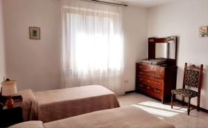 een slaapkamer met 2 bedden, een dressoir en een raam bij My Holidays - Casa Laura in Domaso