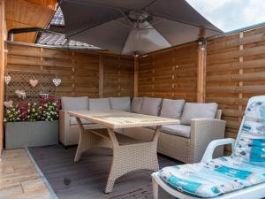 a patio with a table and chairs and an umbrella at agropensiunea CASA NICA in Mărgineni